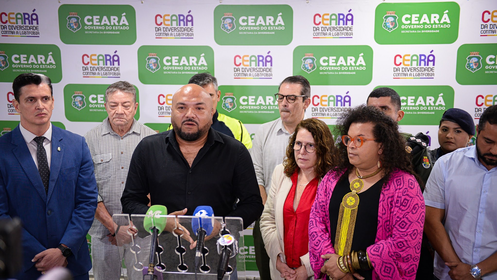 grupo de pessoas diante dos microfones da coletiva de imprensa do plano operacional da parada da diversidade